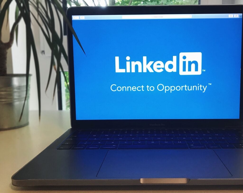 How journalists decide whether you're a credible spokesperson - Laptop with a blue LinkedIn screen displaying "Connect to Opportunity," set against a bright, natural light background and a plant.