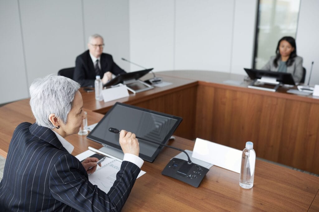 Why Media Training matters in the energy sector. Few industries sit as firmly in the public spotlight as the energy sector. A diverse group of professionals in business attire engaged in a meeting at a modern conference table, with digital devices present.
